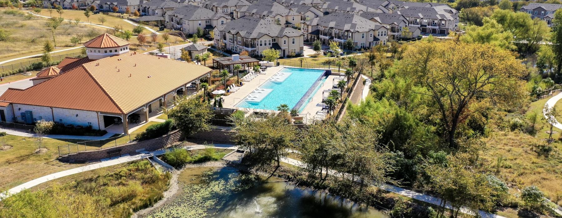 a pool surrounded by trees and buildings