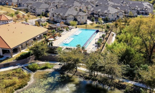 a pool surrounded by trees and buildings