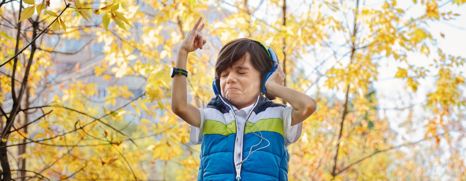 a person wearing headphones and standing in front of trees