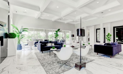 a living room with a large white floor and a large glass wall