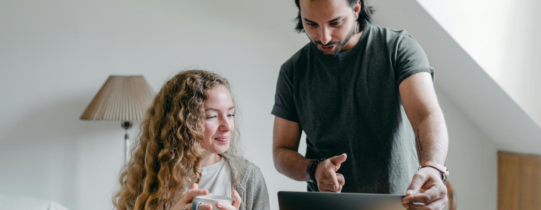 a man and a woman looking at a laptop