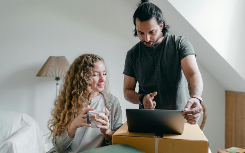 a man and a woman looking at a laptop